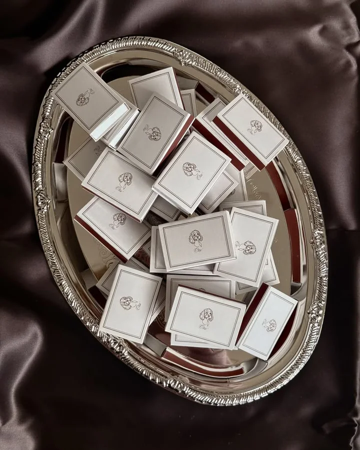 Cajas de cerillas de boda ilustradas sobre una bandeja de plata