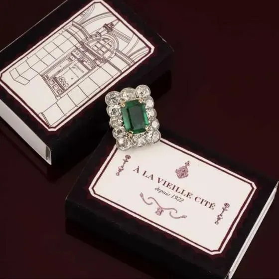 Cajas de cerillas en rojo oscuro y crema para una joyería de París, con un anillo de esmeralda